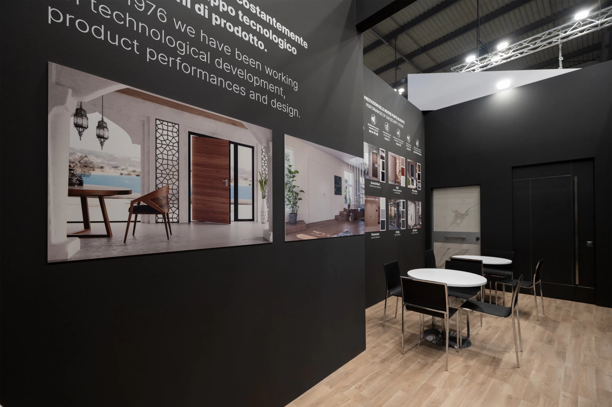 Vista d’insieme di uno stand elegante progettato per Dibi, con grafiche murali che mostrano ambientazioni di design e tavolini per incontri professionali.
